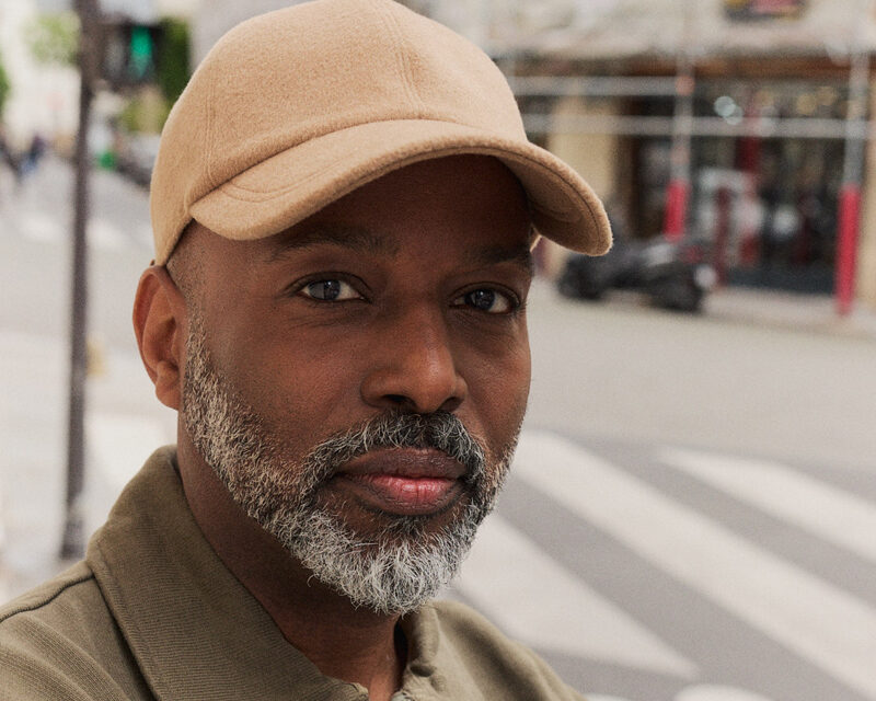 Homme élégant en costume bleu marine portant une casquette en laine